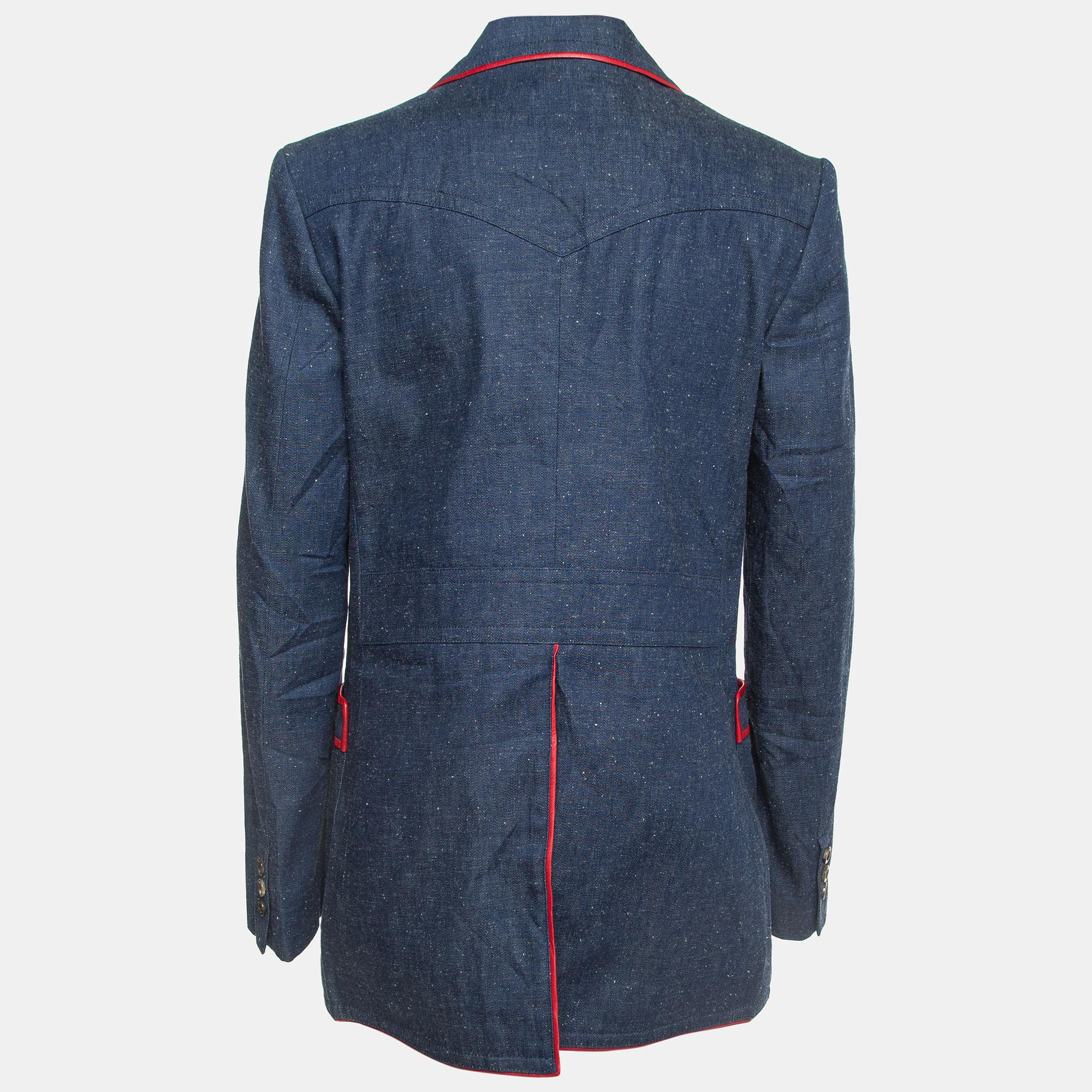 The Gucci blazer embodies sophistication with its sleek design and impeccable craftsmanship. Crafted from high-quality denim, it features luxurious leather trims, adding a touch of elegance to its classic single-breasted silhouette. Ideal for