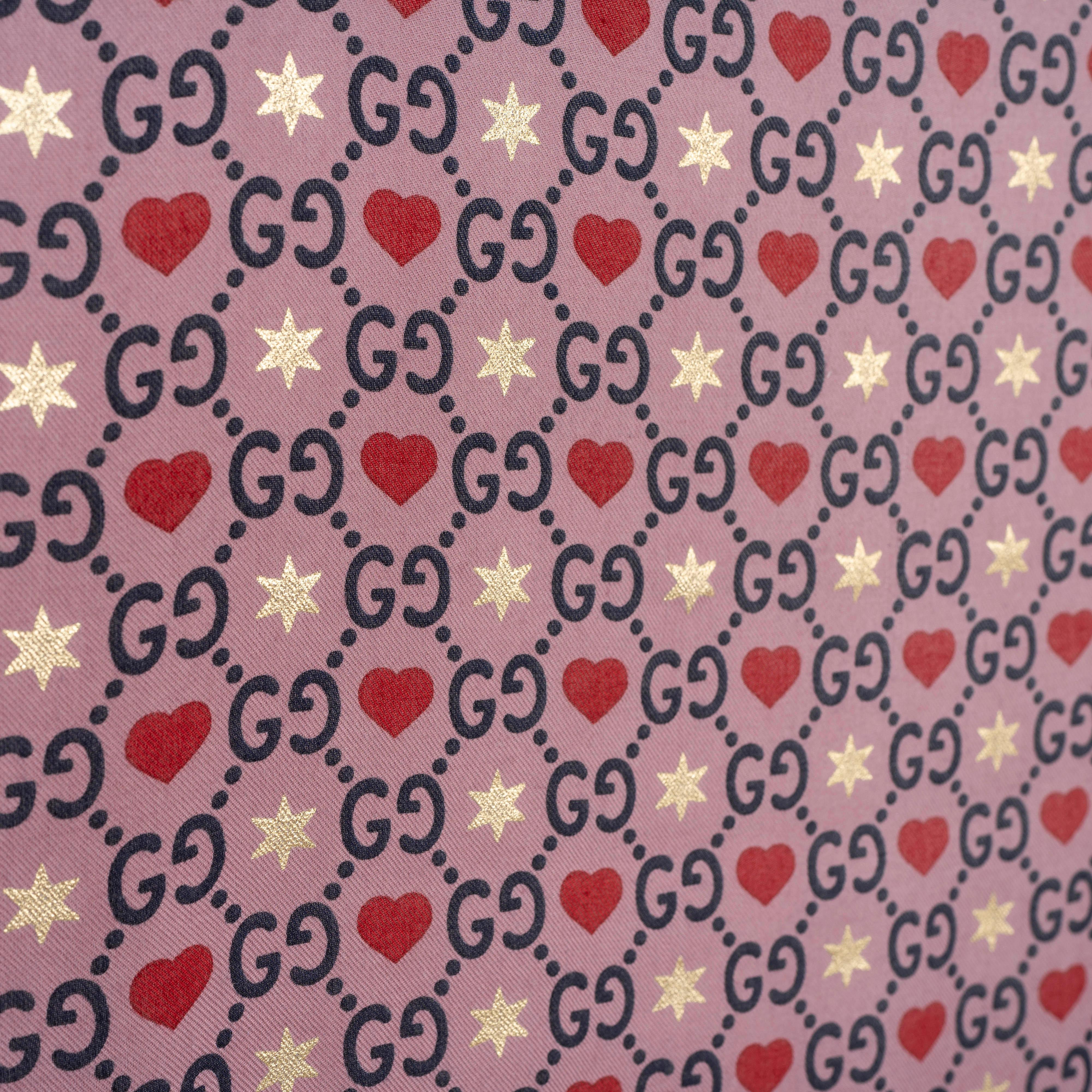 This 100% authentic Gucci GG Hearts & Stars Silk Scarf in mauve is crafted in Italy from an 81% modal and 19% silk blend for a whisper-light feel. It features the interlocking GG pattern embellished with sparkling gold stars and raspberry hearts,