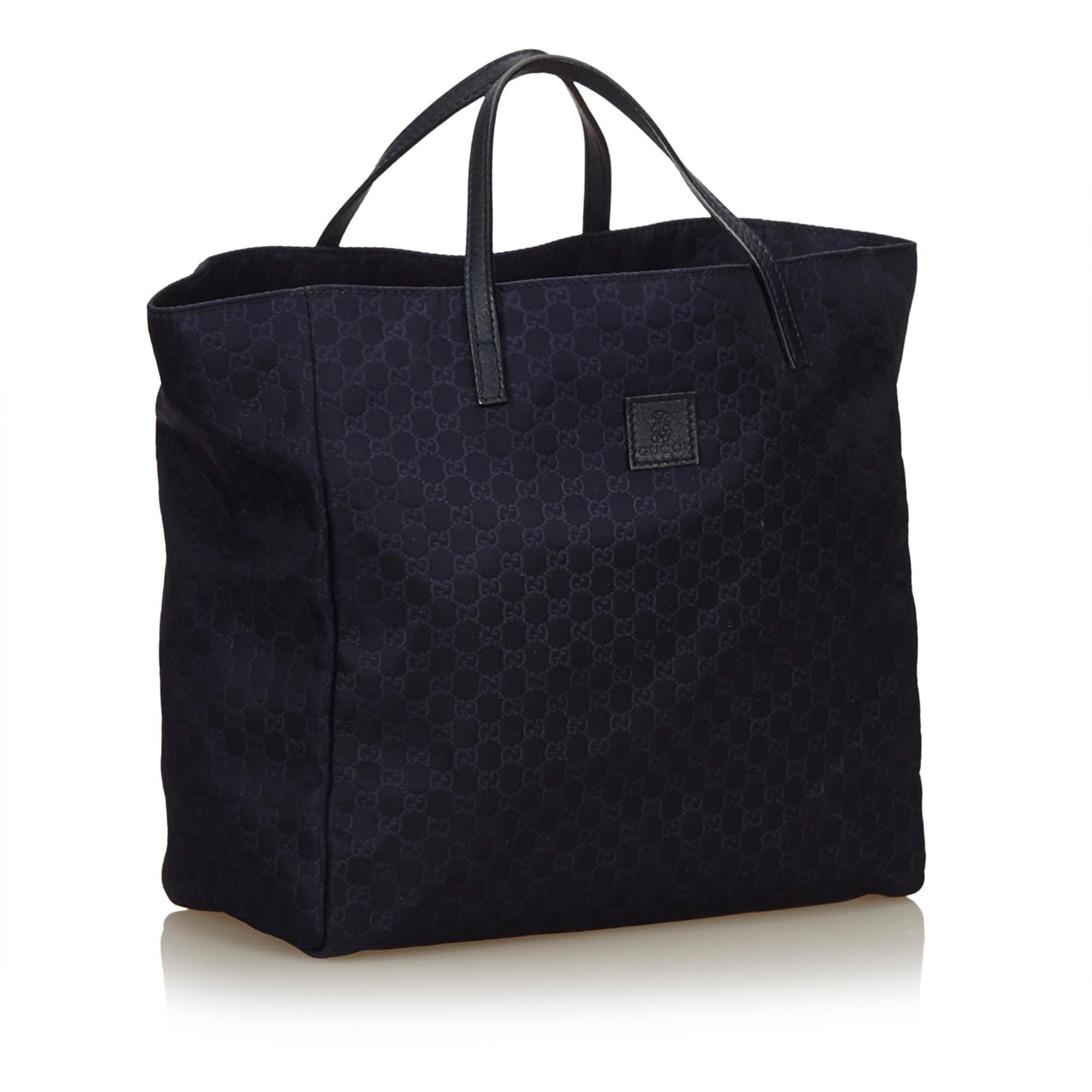 This tote bag features a nylon body, flat leather straps, open top, and interior slip pocket. It carries as B condition rating.

Inclusions: 
Dust Bag

Dimensions:
Length: 23.00 cm
Width: 22.00 cm
Depth: 11.00 cm
Hand Drop: 7.00 cm
Shoulder Drop: