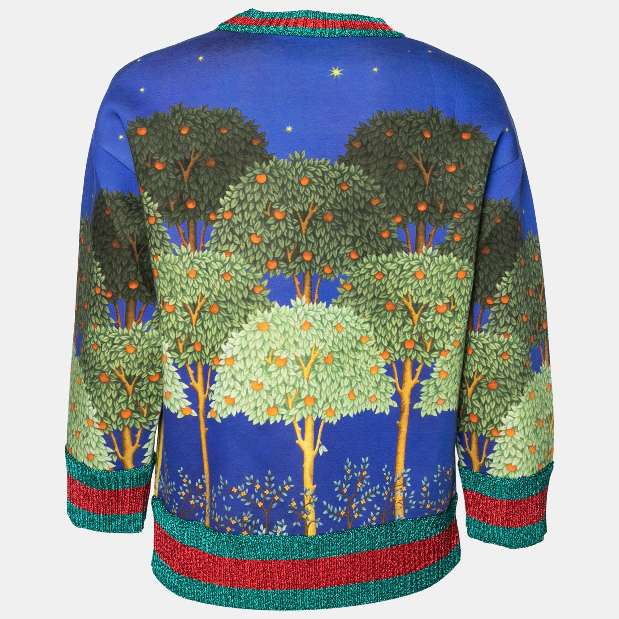 Each of Gucci's creations exhibits signature beauty, elegance, and luxury. This sweatshirt from Gucci will make a luxurious addition to your closet. It is made from blue cotton fabric, with a multicolored Night Garden print augmenting its