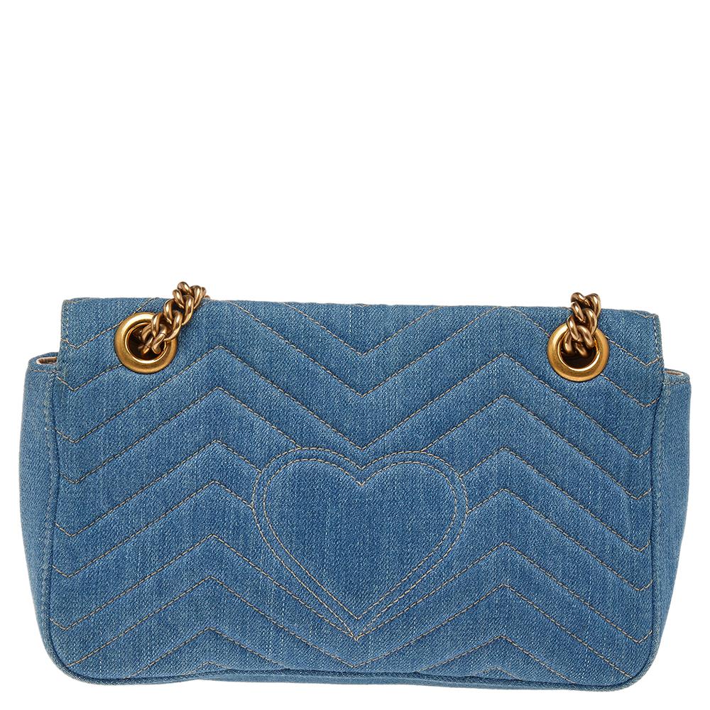 Packed with style and practical design sensibility, this Marmont bag by Gucci is a prized fashion accessory. It is crafted using quilted denim and designed with a flap-enclosed compartment and a shoulder chain. The signature GG detail decked with
