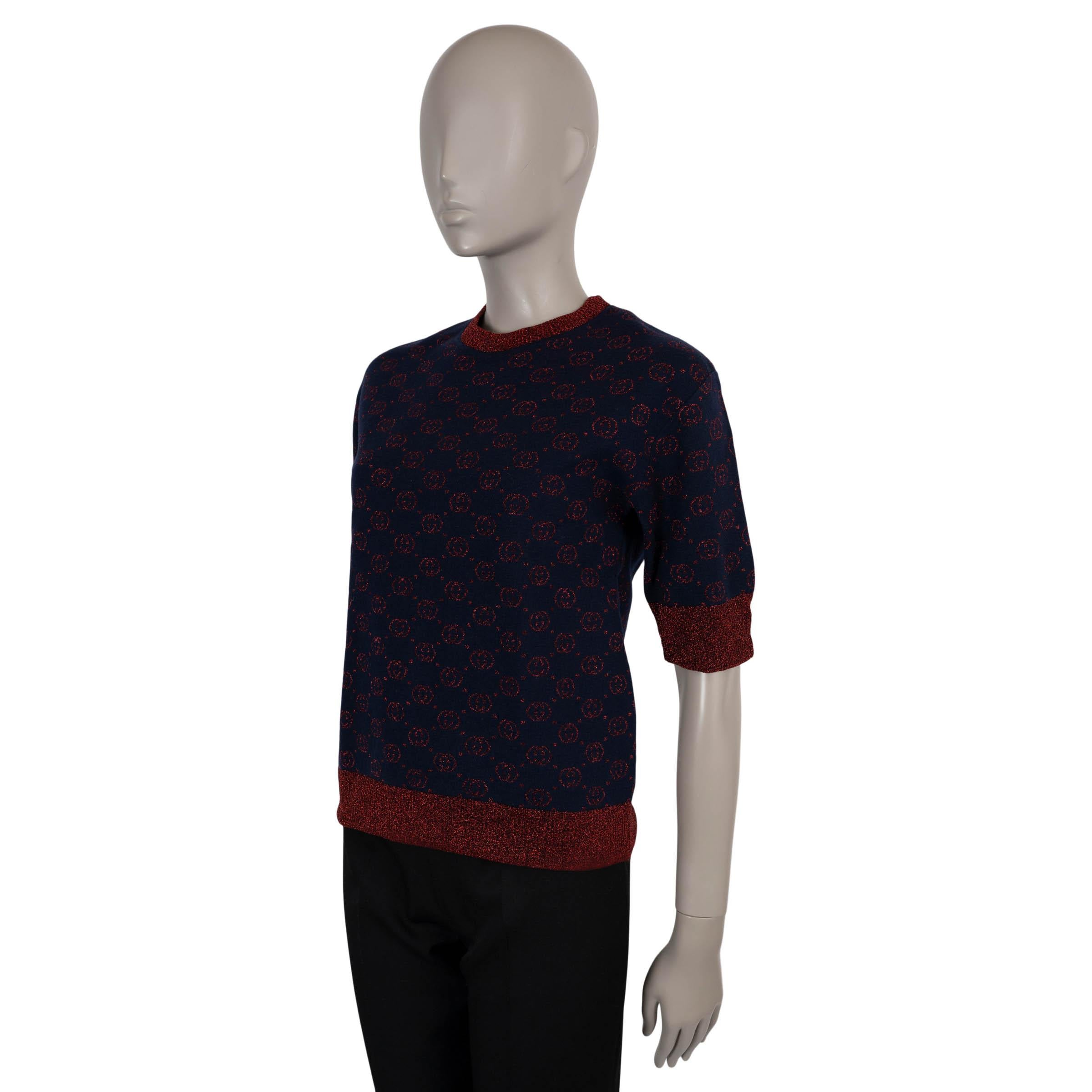 Questo maglione 100% autentico di Gucci è realizzato in maglia jacquard GG lamé blu navy e rossa in lana (76%), poliammide (12%) e fibre metalliche (12%). Presenta una silhouette rilassata con girocollo, mezze maniche e bordi a costine a contrasto