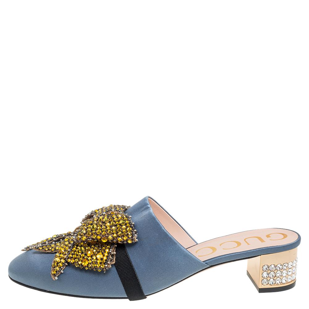 Gucci knows best how to incorporate fancy designs into their creations to make them appear unique. These mules from Gucci lend an exceptional aesthetic with their precisely shaped exterior. Blue satin with a crystal-embellished bow is used to craft