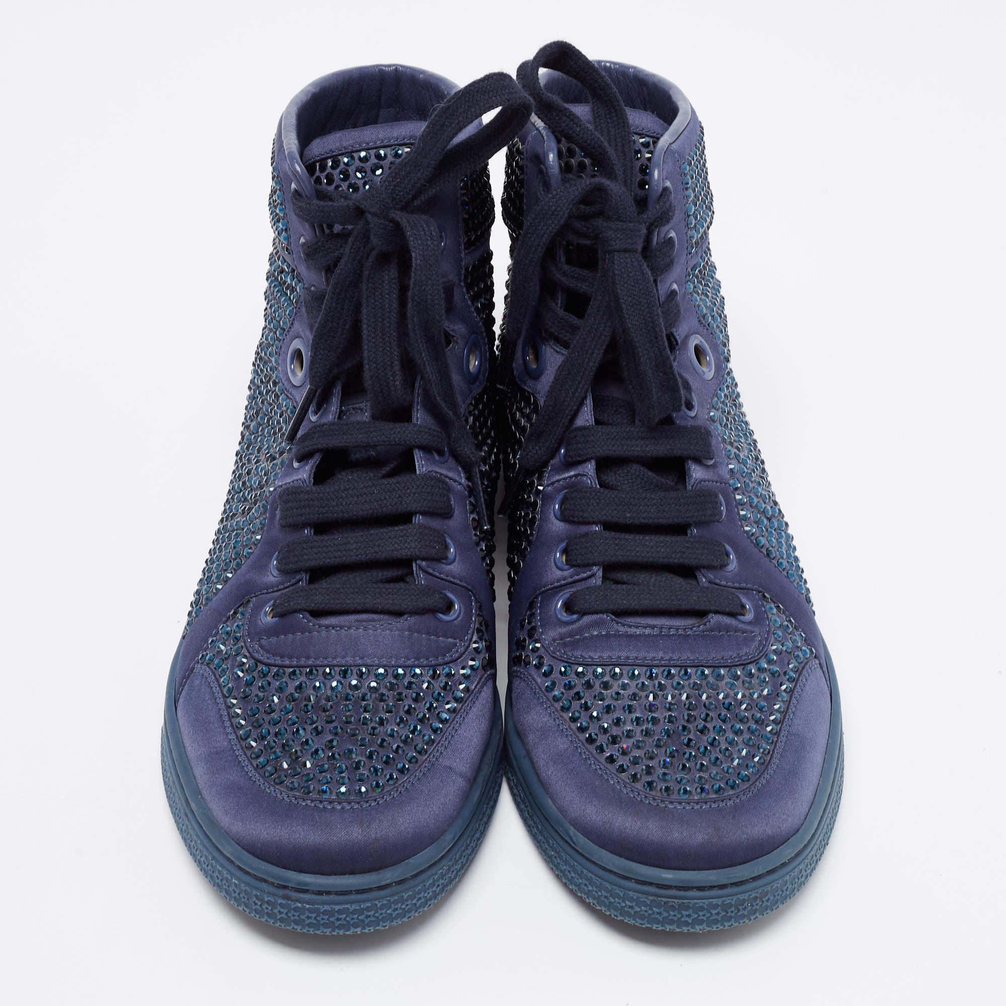 Coming in a high-top silhouette, these Gucci sneakers are a seamless combination of luxury, comfort, and style. They are made from satin in a blue shade and accented with crystals all over the exterior. These sneakers are designed with round-toes,