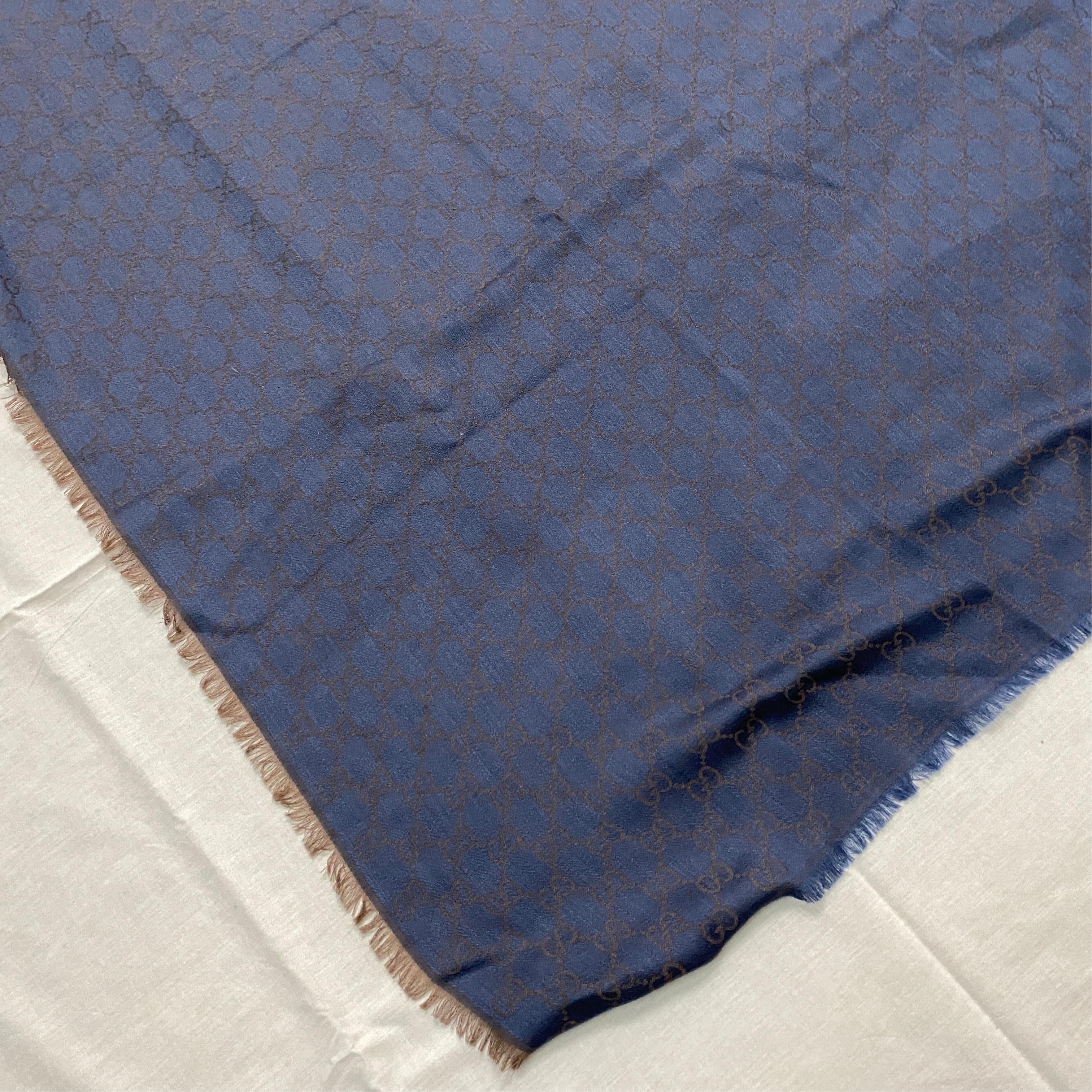 A never worn Blue Scarf in Wool and Silk with GG continuous logo manufactured and designed By Gucci. This scarf is a luxurious and stylish accessory that showcases the iconic Gucci motif. Gucci is a renowned Italian fashion brand known for their