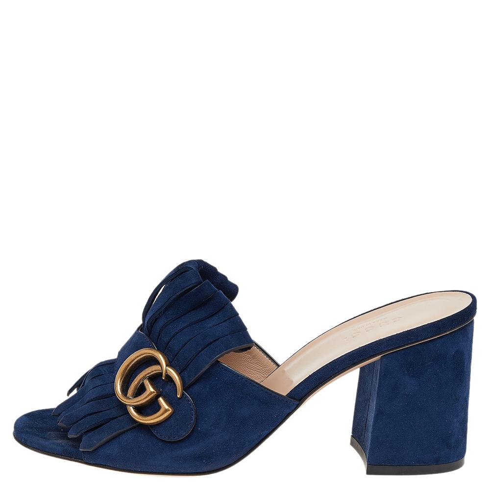 One of the iconic and instantly recognizable designs from the house of Gucci, these GG Marmont mules are here to stay. Crafted in soft blue suede, these mules feature covered block heels for comfort along with folded fringed details over the vamps
