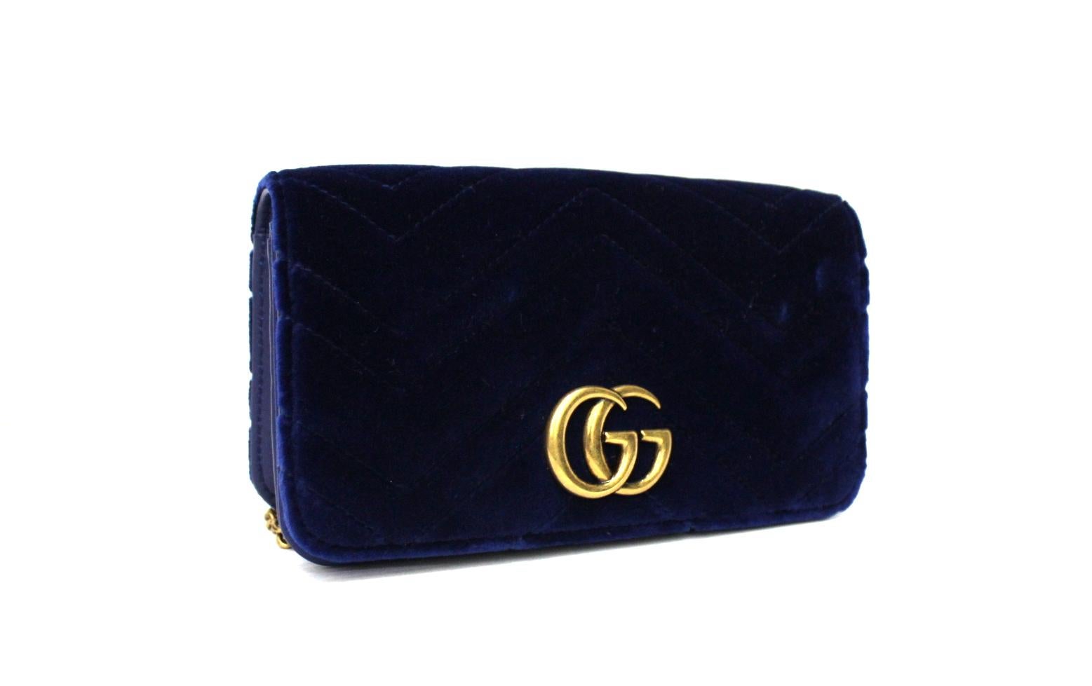 Fantastic Gucci Marmont clutch bag made of velvet in a beautiful shade of blue contrasting with golden hardware.

Equipped with magnetic flap closure, internally not very large. Equipped with chain shoulder strap.

The bag is in impeccable
