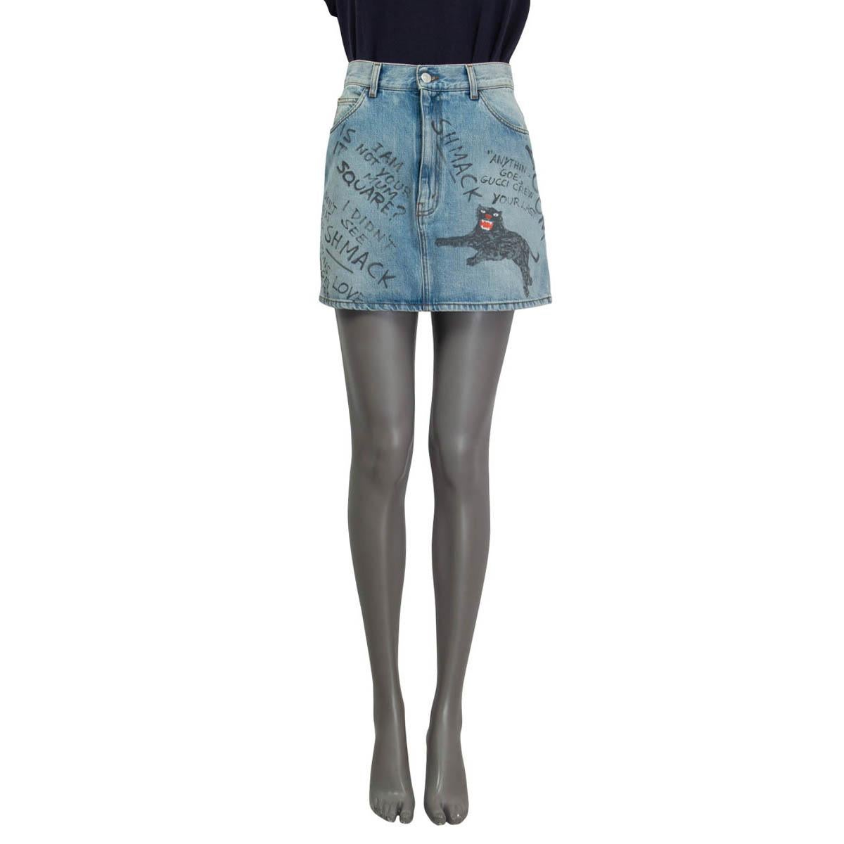 100% authentic Gucci denim mini skirt in washed out light blue cotton (100%). Features a scribbled gray writing and a panther on the skirt. Has two slit pockets on the front and two on the back. Opens with a 'Gucci' button and a concealed zipper on