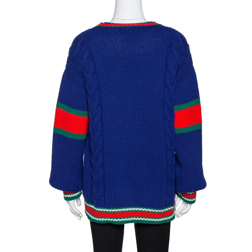 This trendy sweater hails from Gucci's DIY collection that explores customizable unisex knitwear. This sweater is crafted in Italy and made from pure wool. The cable knit exterior carries a blue hue, green & red stripe detailing and the letter 'R'