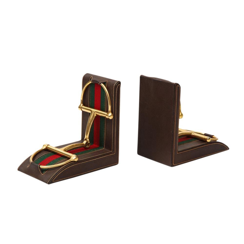 Gucci Bookends, leather, brass, horsebit, signed. Large scale handcrafted bookends decorated with brass stirrups over green/red fabric and chocolate brown stitched leather. Marked: 