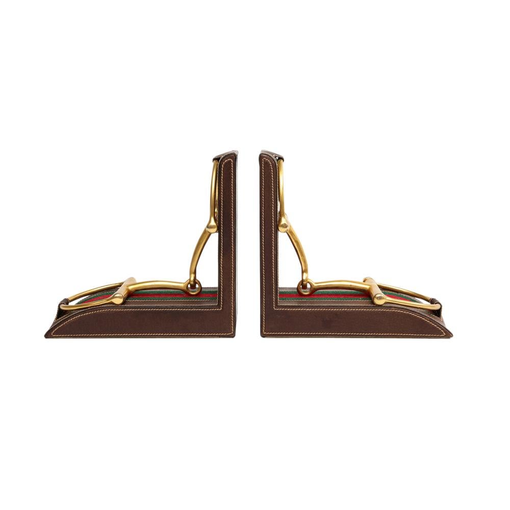 Gucci bookends, leather, brass, horsebit, signed. Handcrafted equestrian themed bookends in walnut brown stitched leather with brass stirrups over green and red striped fabric. Marked: 