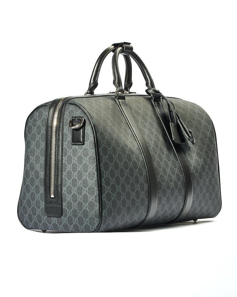 Die charakteristische Gucci-Reisetasche, mittelgroß, aus Canvas im GG Supreme-Muster mit Lederbesatz und silberner Hardware. Ausgestattet mit einem halbrunden Reißverschluss mit doppeltem Schieber, innen gefüttert mit Ton-in-Ton-Canvas und zwei