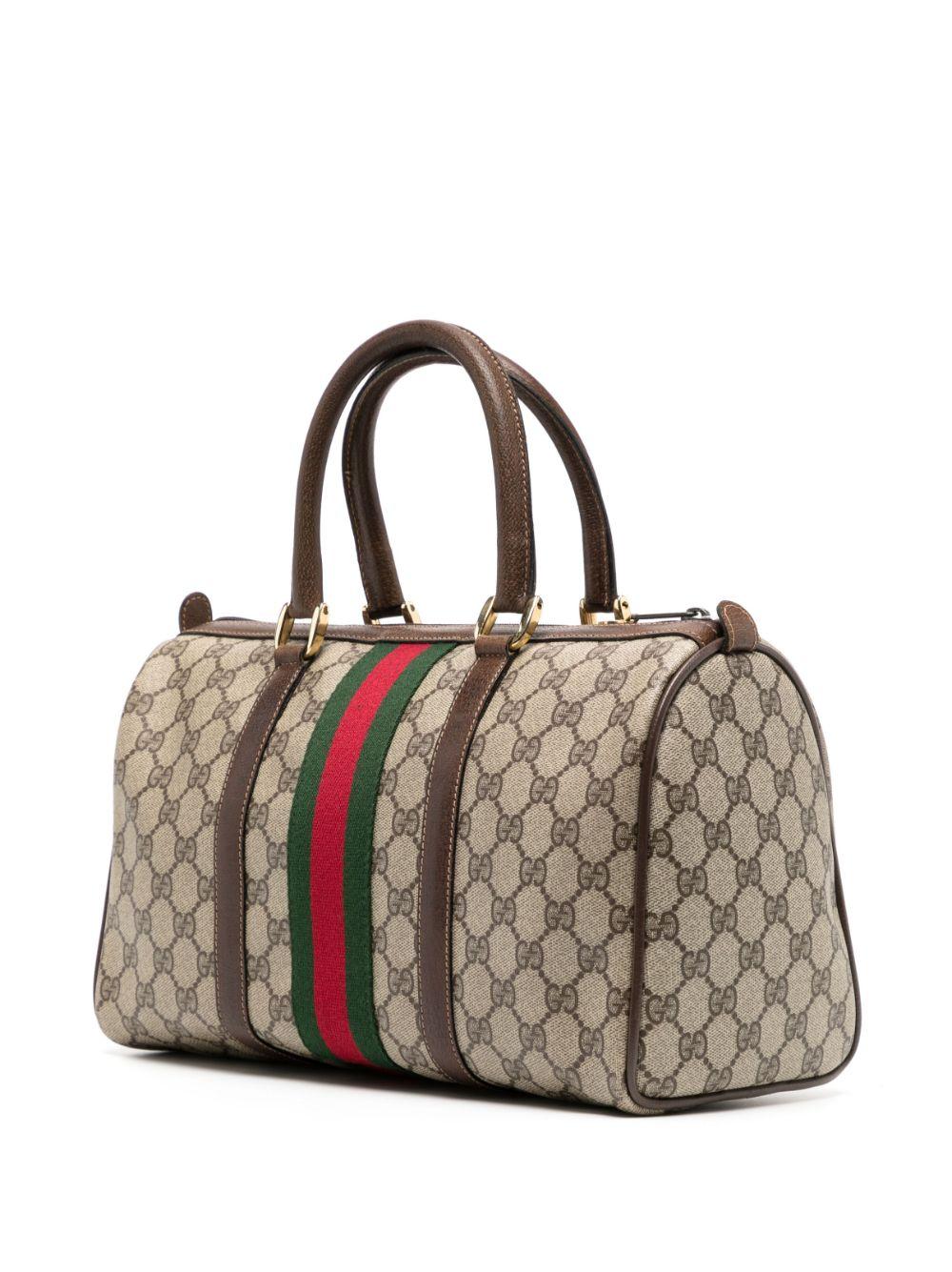 This Boston bag by Gucci is crafted from canvas with leather details and handles featuring the classic GG print in light grey and brown. This top handle style with the oblong bottom is enclosed with a zip and finished with golden-tone hardware.