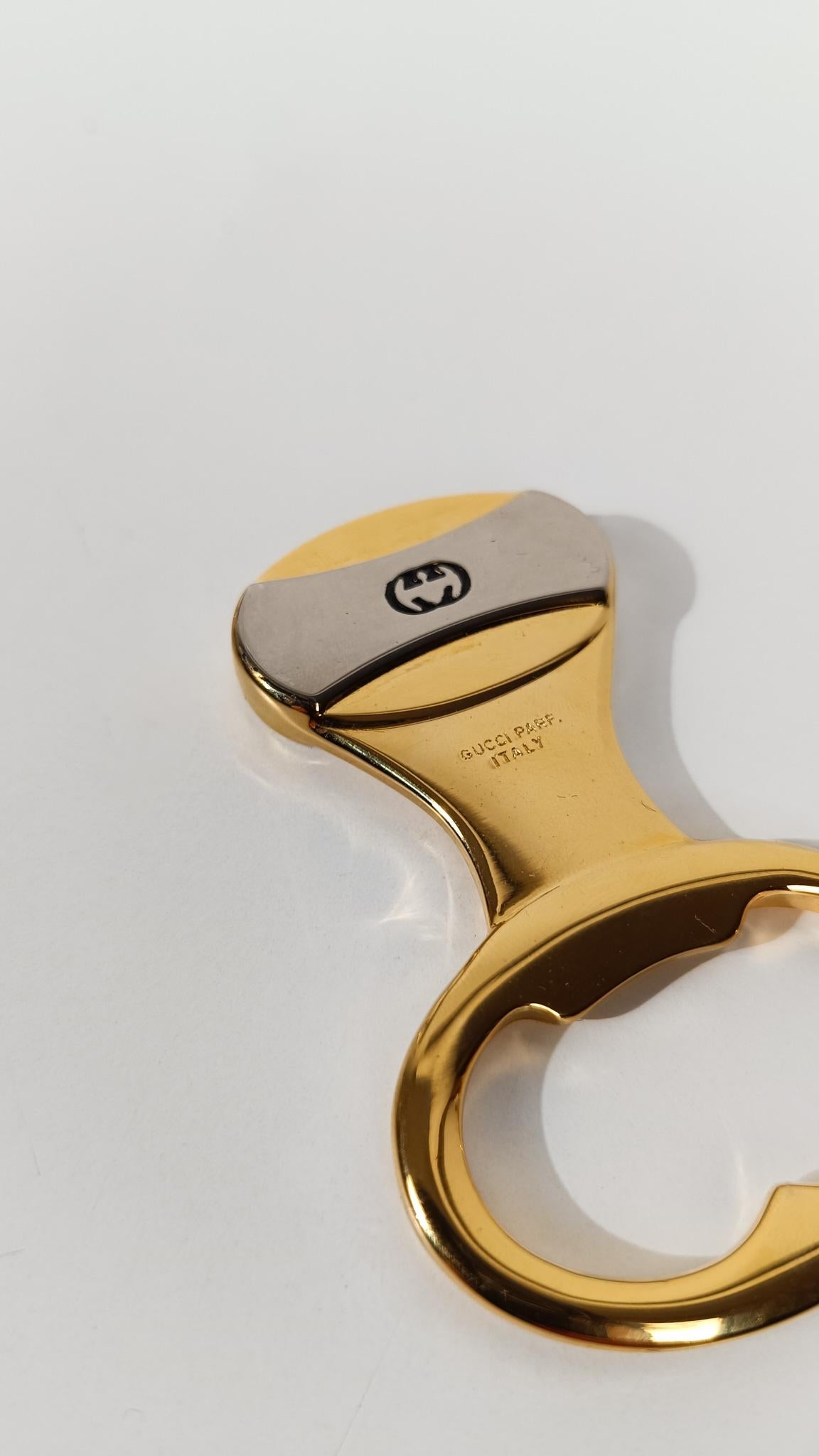 Wir freuen uns, einen eleganten Vintage-Flaschenöffner von Gucci zum Verkauf anbieten zu können.

Dieser in den 1970er Jahren in Italien hergestellte Flaschenöffner besticht durch sein schlichtes, minimalistisches Design aus goldfarbenem Messing und