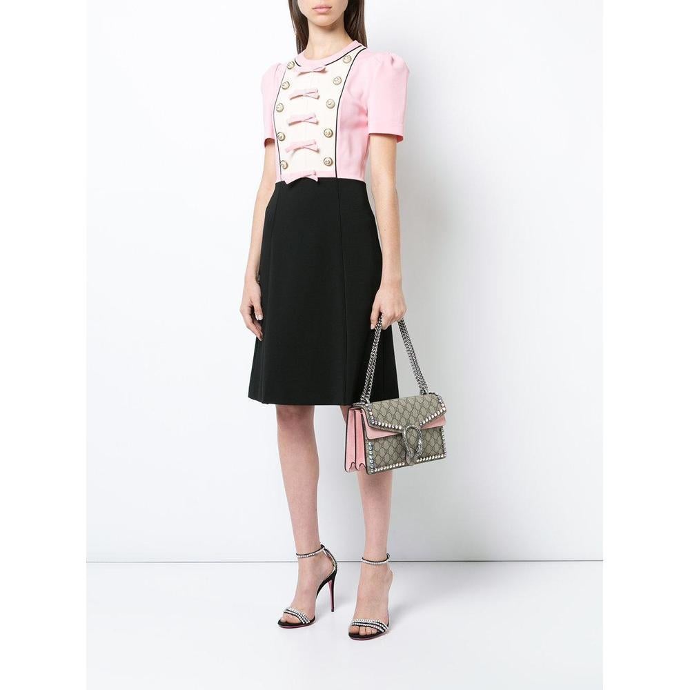 A crisp piece that showcases the elegance expected of the famous Gucci design house, this dress is an essential for the chic woman's wardrobe.
Made in Italy, this Gucci dress features a contrasting skirt and top, bow and button detail, short