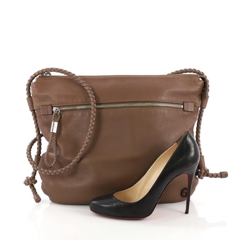 This Gucci Braided Strap Zip Messenger Leather Medium, crafted in brown leather, features a braided shoulder strap, exterior zip pocket and silver-tone hardware. Its zip closure opens to a beige fabric interior with zip and slip pockets. **Note: