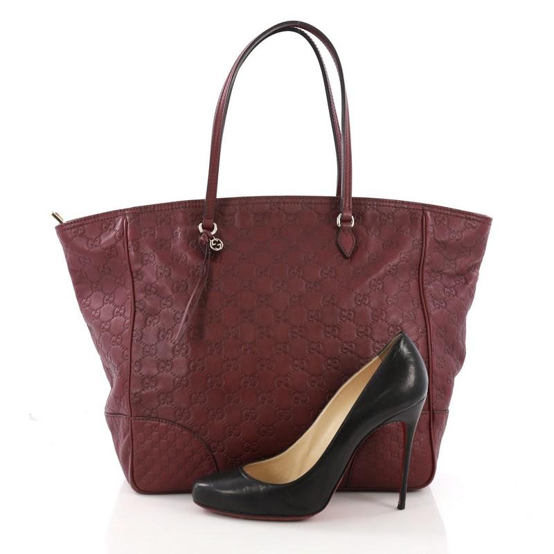 This Gucci Bree Tote Guccissima Leather Medium, crafted in burgundy guccissima leather, features dual tall slim handles and gold-tone hardware. Its zip closure opens to a beige canvas interior with side zip and slip pockets. **Note: Shoe