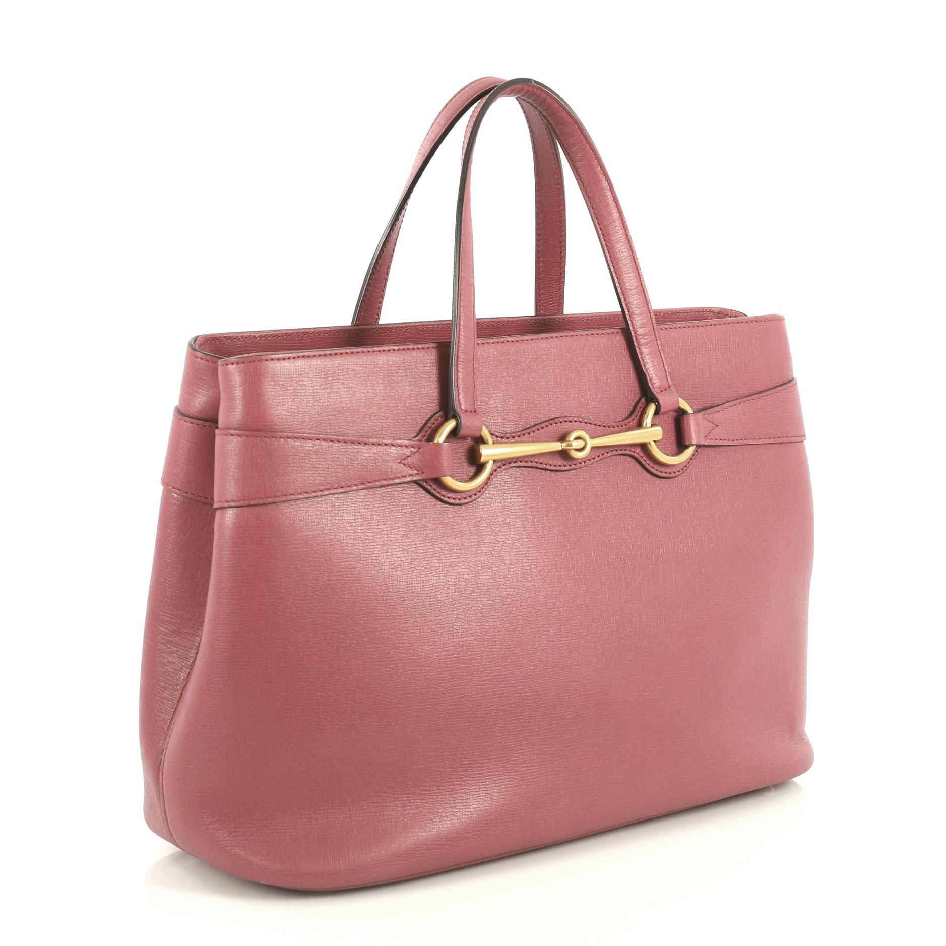 This Gucci Bright Bit Convertible Tote Leather Medium, crafted in pink leather, features dual top handles, signature horsebit design, side snap buttons and aged gold-tone hardware. It opens to a neutral fabric interior with side compartments and