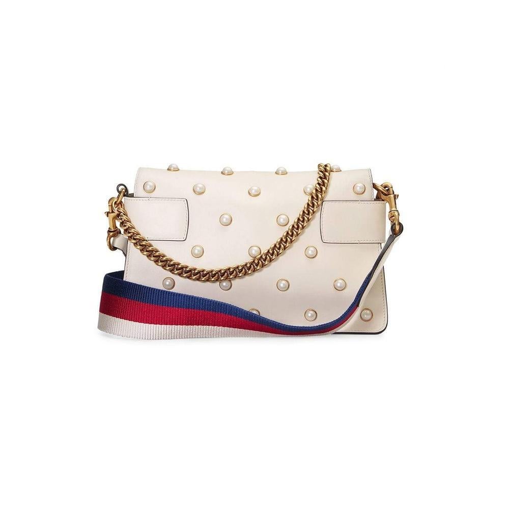 A chain clutch with all over pearl studs and metal bee detail.
The striped body is highlighted with blue enamel and red crystal stones and the wings are embellished with pearl effect studs.
White leather with pearls.
Metal bee with pearls and