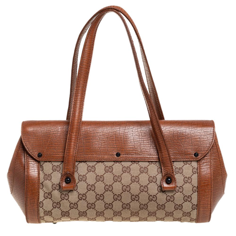 Coming from the house of Gucci, this Bullet satchel features a brown and beige GG canvas body and detailed with leather trims. It features a long silhouette and topped with two flat top handles. Detailed with a bamboo accent on the top, this bag is