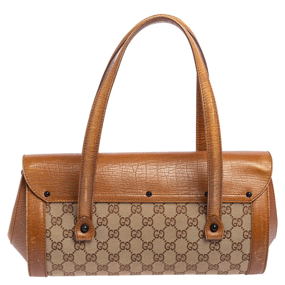 Coming from the house of Gucci, this Bullet satchel features a brown and beige GG canvas body detailed with leather trims. It features a long silhouette and is topped with two flat top handles. Detailed with a bamboo accent on the top, this bag is