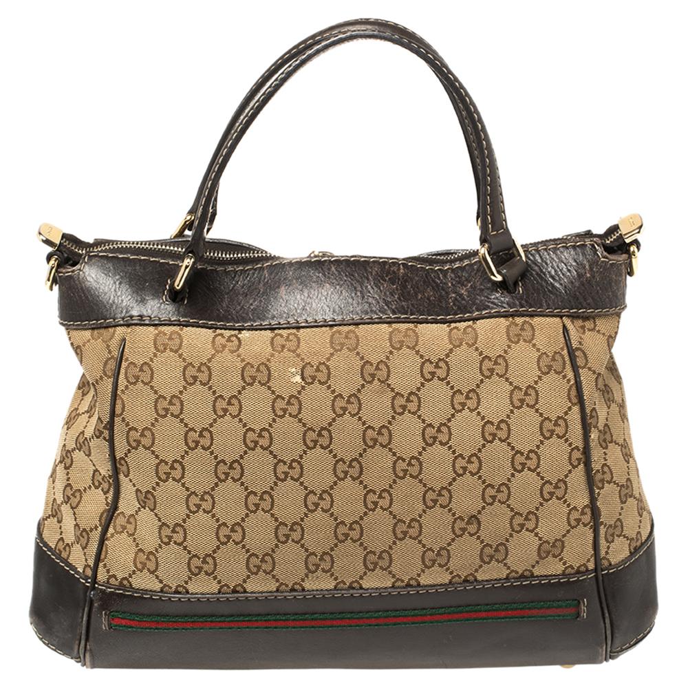 This stunning tote by Gucci is perfect for everyday use. Crafted from the signature GG canvas and leather, it has a classic silhouette. The beige and brown-hued bag has two handles, gold-tone hardware, signature web detailing near the base, a