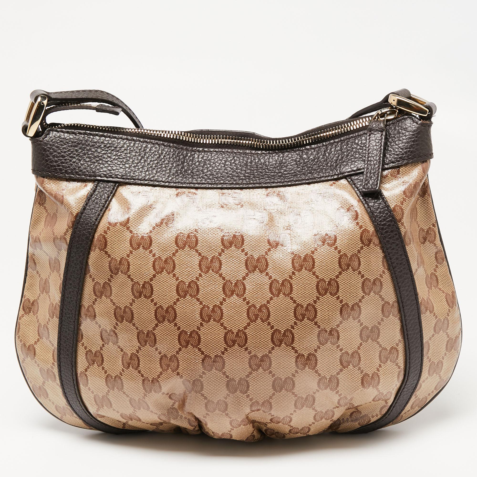 Elegance meets luxury in this Abbey D-Ring crossbody bag from the House of Gucci. It is created using brown-beige GG canvas and leather, which is highlighted with gold-tone hardware. It is completed with a shoulder strap. This stunning Gucci bag