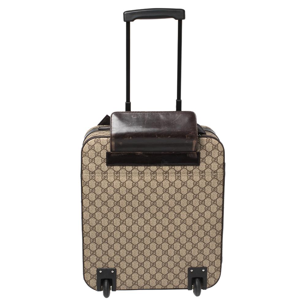 To elevate your traveling experience, Gucci brings you this reliable suitcase. It has been crafted from the brand's signature GG Supreme canvas and leather trims. Equipped with a top handle, a telescopic handle, and a spacious interior lined with
