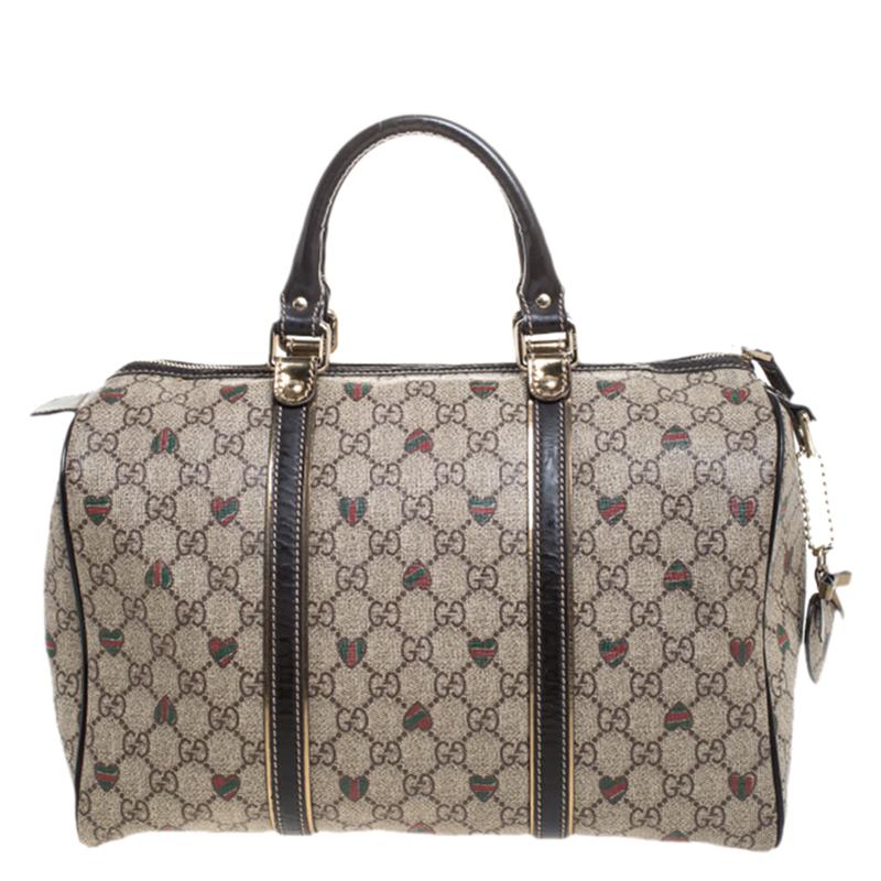 This trendy Joy Boston bag by Gucci is a buy you won't regret. Crafted from GG supreme canvas it styled with leather trims and tattoo hearts. The bag has a well-sized canvas interior and two top handles for you to easily swing. The piece is complete