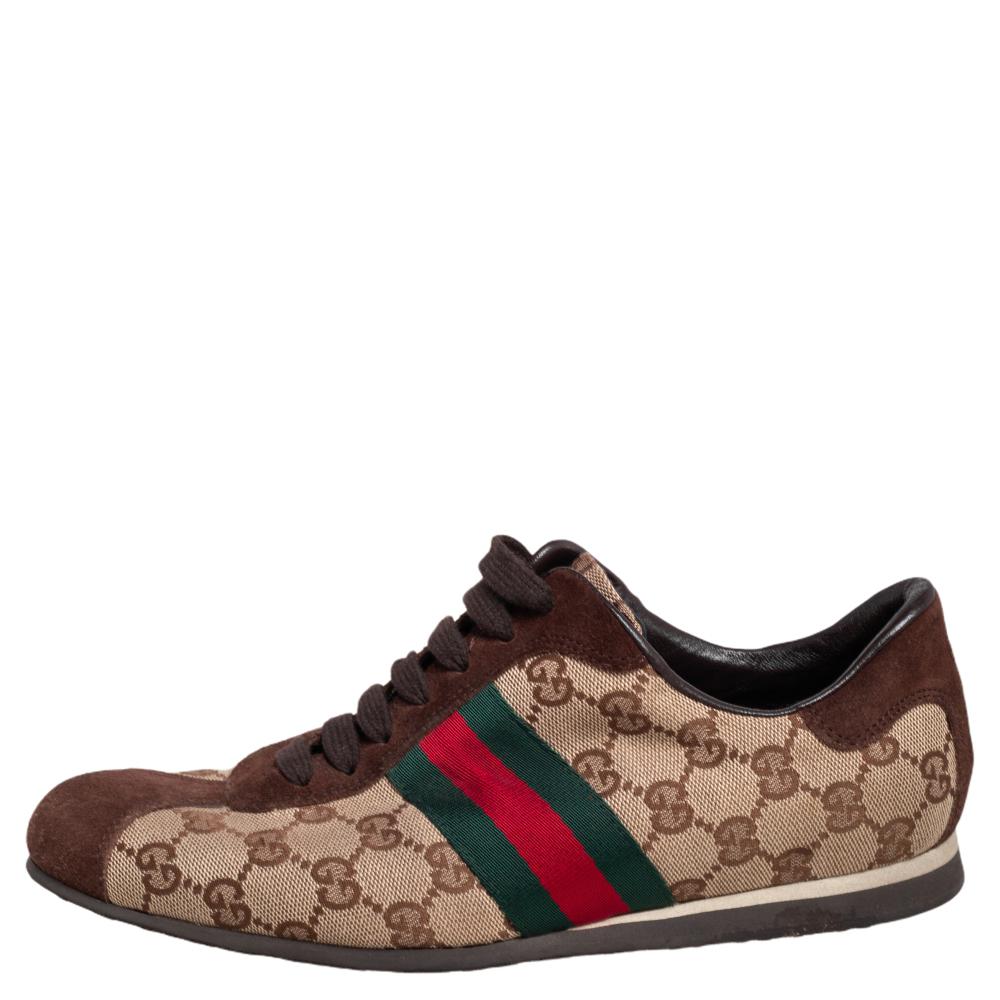 Look stylishly comfortable with these Gucci low-top sneakers. They are made from GG monogram canvas in beige with contrasting brown suede trim and web detailing. These come with lace-ups, logo detailing on the counters, leather-lined insoles, and