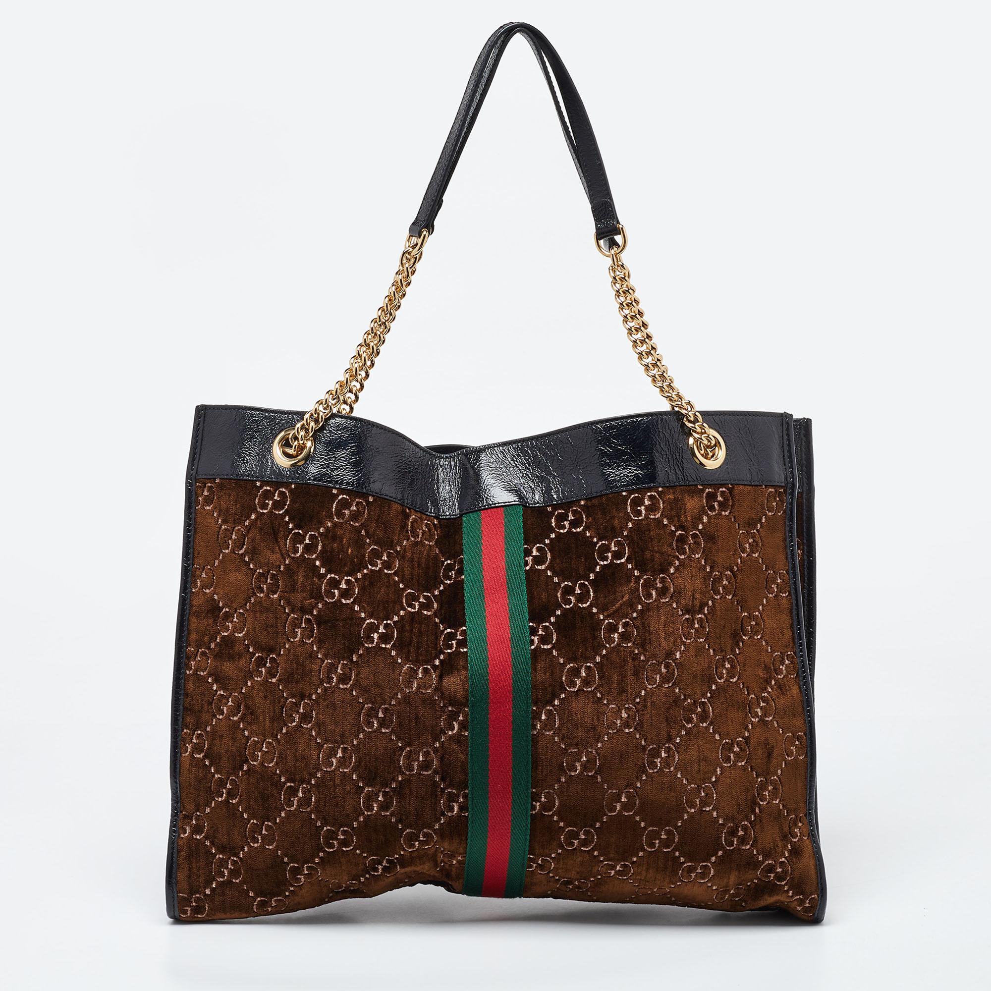 Channel your love for luxurious styles with this Rajah tote by Gucci. The well-sized Alcantara interior and the dual shoulder handles make this bag functional. It is finished with recognizable House codes and gold-tone hardware.

Includes: Original