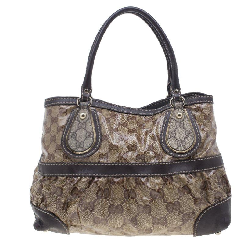 Classically printed and great for daytime, this Crytal Mix Tote by Gucci is a wardrobe must! This medium tote is crafted from beige GG coated canvas with brown leather trim. The everyday look is completed with leather handles and light gold-tone