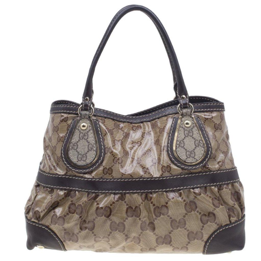 Classically printed and great for daytime, this Crytal Mix Tote by Gucci is a wardrobe must! This medium tote is crafted from beige GG coated canvas with brown leather trim. The everyday look is completed with leather handles and light gold-tone