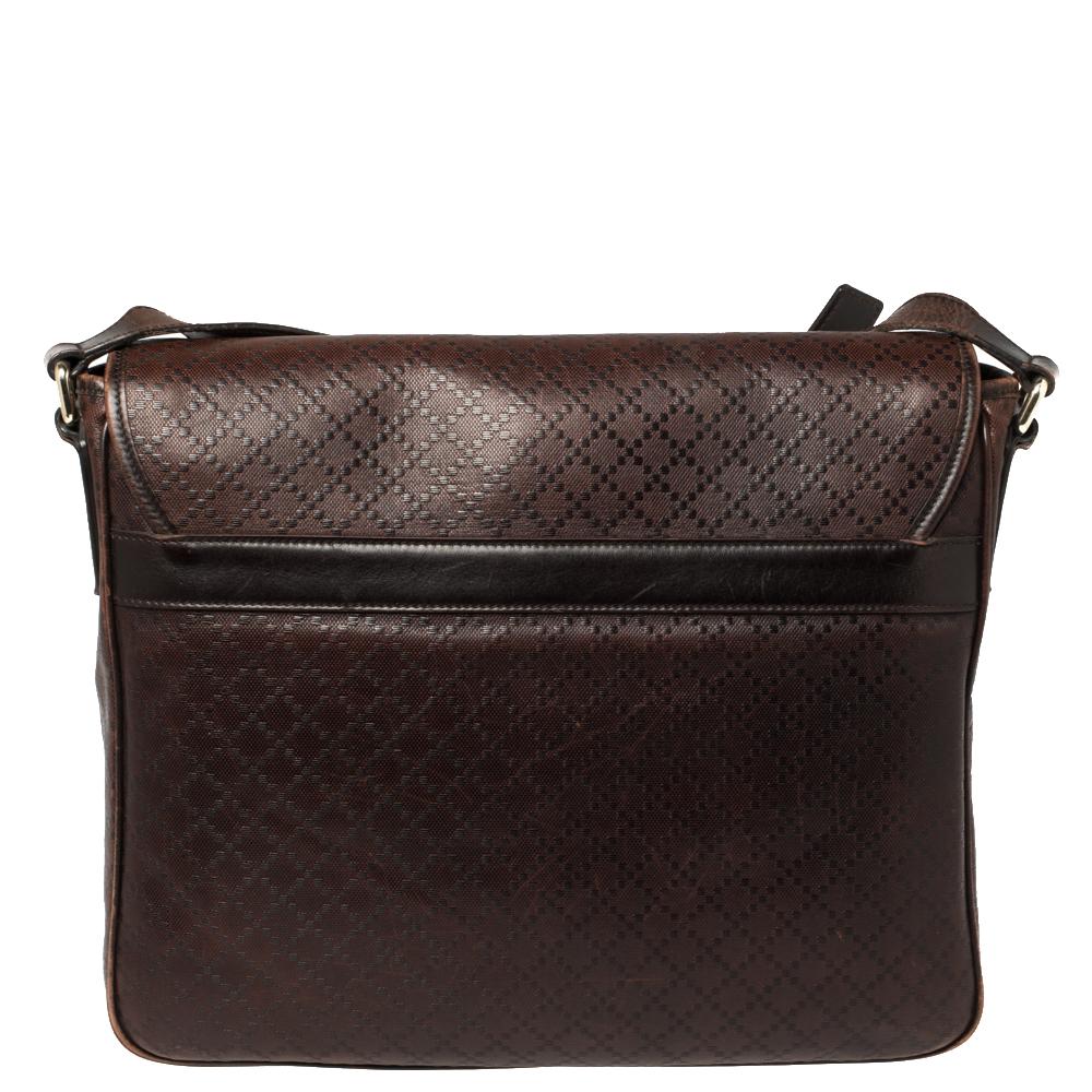 This Gucci bag is comfortable to carry without compromising on style. Crafted from brown Diamante leather, the bag comes with a front flap and a shoulder strap. It opens to a fabric-lined interior that houses a slip compartment and phone holder