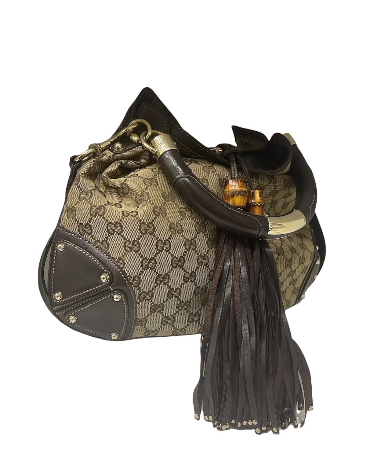 Gucci signed bag, Indy model, made of GG Supreme fabric, with brown leather inserts and golden hardware. Equipped with a magnetic button closure, internally lined in beige fabric, very roomy. Equipped with a rigid leather handle and an internal zip