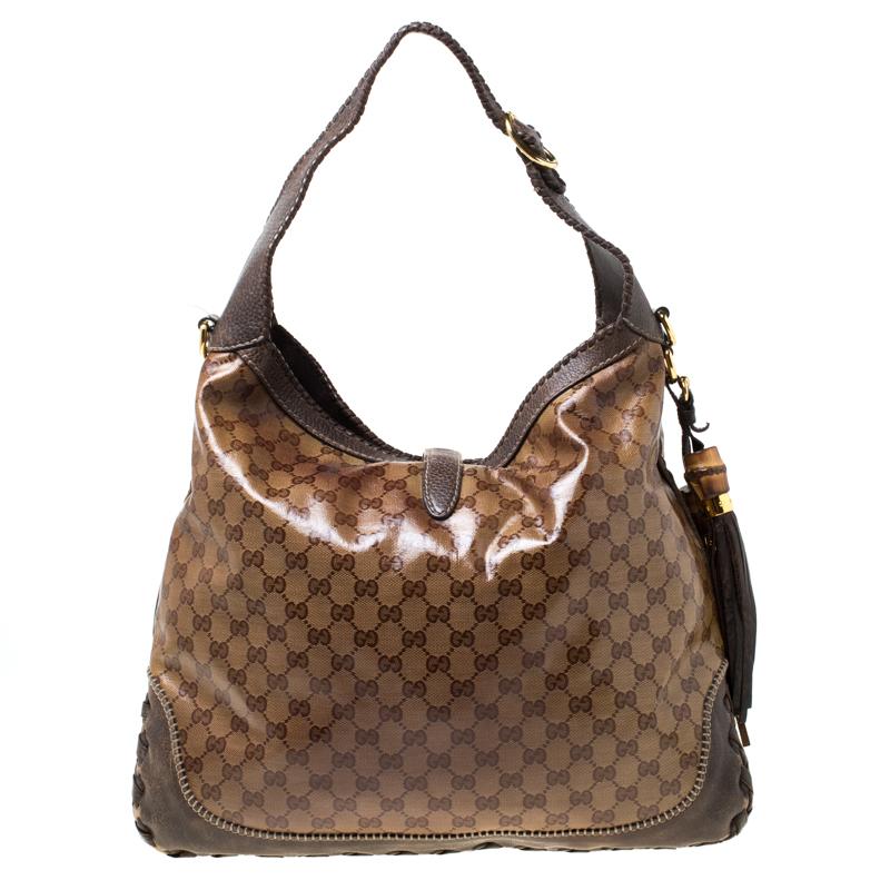This Gucci bag will never fail you. Crafted from GG Crystal Canvas and leather in Italy, this gorgeous number has the signature closure in gold-tone that opens up to a spacious canvas interior. Complete with a single handle, this bag is ideal for