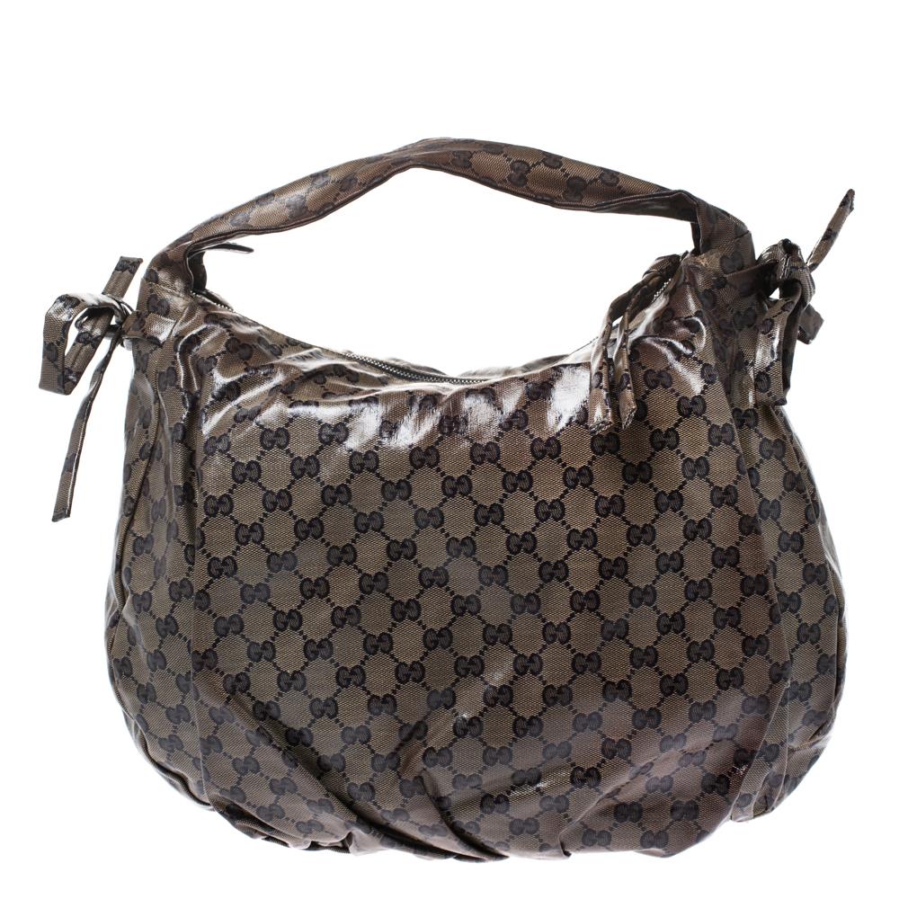 This Gucci hobo is built for everyday use. Crafted from GG crystal canvas, it has a brown exterior and two handles for you to easily parade it. The nylon insides are sized well and the Hysteria hobo is complete with the signature emblems in