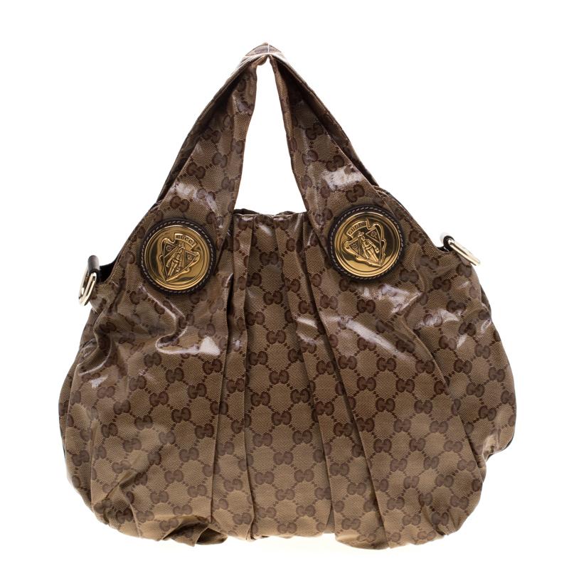 This Gucci hobo is built for everyday use. Crafted from GG crystal canvas, it has a brown exterior and two handles for you to easily parade it. The nylon insides are sized well and the Hysteria hobo is complete with the signature emblems in