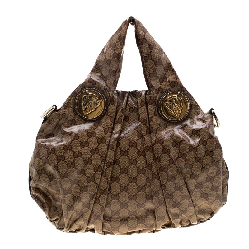 This Gucci hobo is built for everyday use. Crafted from GG crystal canvas, it has a brown exterior and two handles for you to easily parade it. The nylon insides are sized well and the Hysteria hobo is complete with the signature emblems in