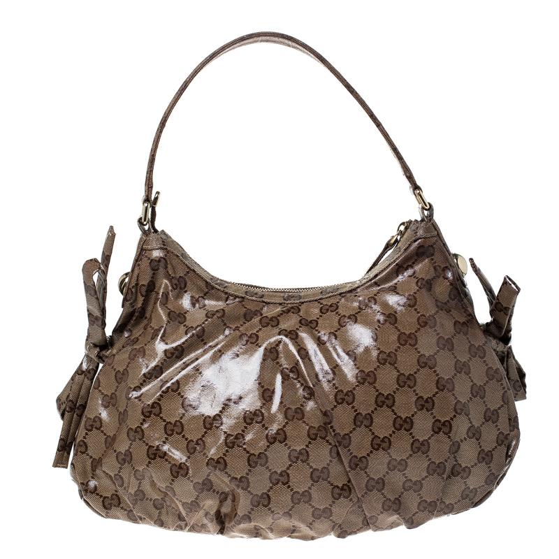 This handbag from the house of Gucci can work well for any occasion. The bag is crafted from GG crystal canvas and is enhanced with the web stripe on the front. It is held by a single handle and the zip-top closure opens to a canvas-lined interior