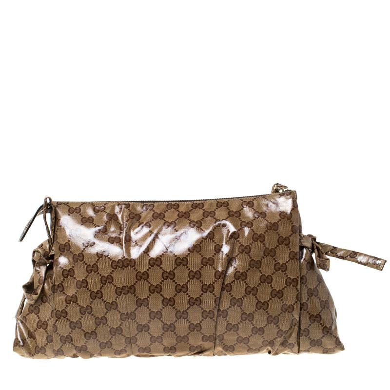 This Gucci clutch is built to suit your stylish ensembles. Crafted from GG crystal coated canvas, it has a brown shade and a zipper which secures a nylon interior. The clutch is complete with the signature Hysteria emblem on the front and a