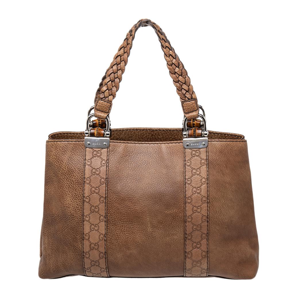 Bags from Gucci are on every woman's wishlist. So, own this gorgeous tote today and light up your closet! Crafted from GG leather & leather, this fabulous accessory has dual braided handles that are anchored by D-rings and the signature bamboo bars.