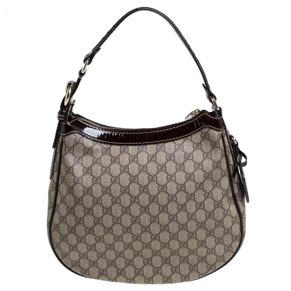 Diese Hobo von Gucci ist aus GG Supreme Canvas gefertigt und hat die perfekte Größe. Ihr braunes Äußeres ist mit Lacklederbesätzen:: einem einzelnen Henkel und einem Gucci-Schild versehen. Der Innenraum ist mit Canvas gefüttert und hat ein