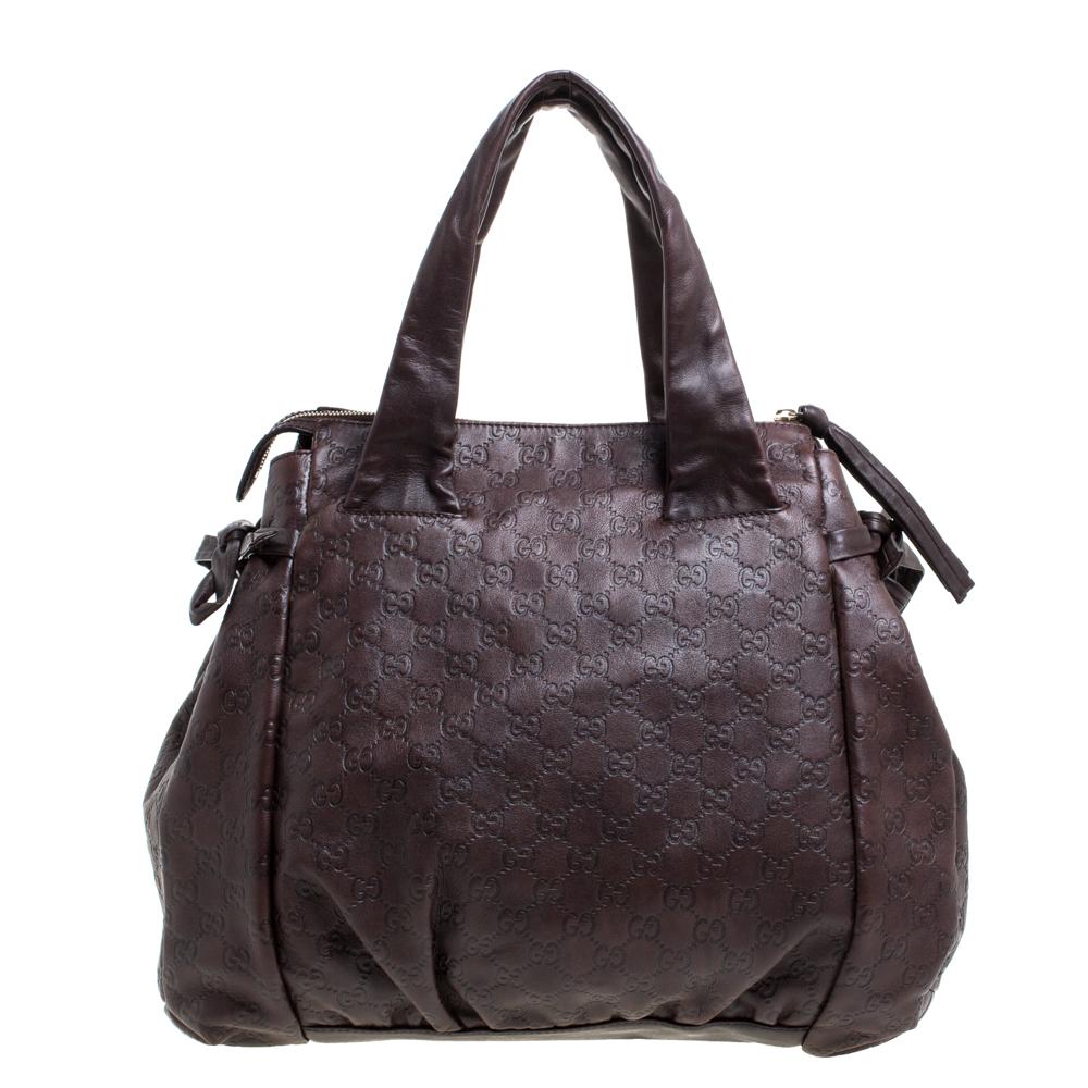 This Gucci tote is built for everyday use. Crafted in Italy, it is made from Guccissima leather and comes in a brown hue. It has ties on the sides and dual handles for you to parade it. The canvas interior is spacious and is secured with a zip