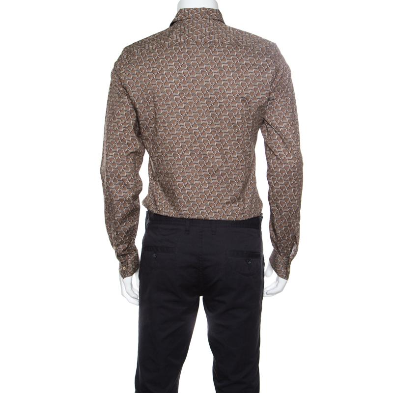 Look smart in this minimalist shirt from Gucci featuring a horsebit print all over. The cotton fabric and a slim fit silhouette ensure a smooth and perfect fit. Graced with a subtle brown hue, it the ideal pick for all casual occasions.

Includes: