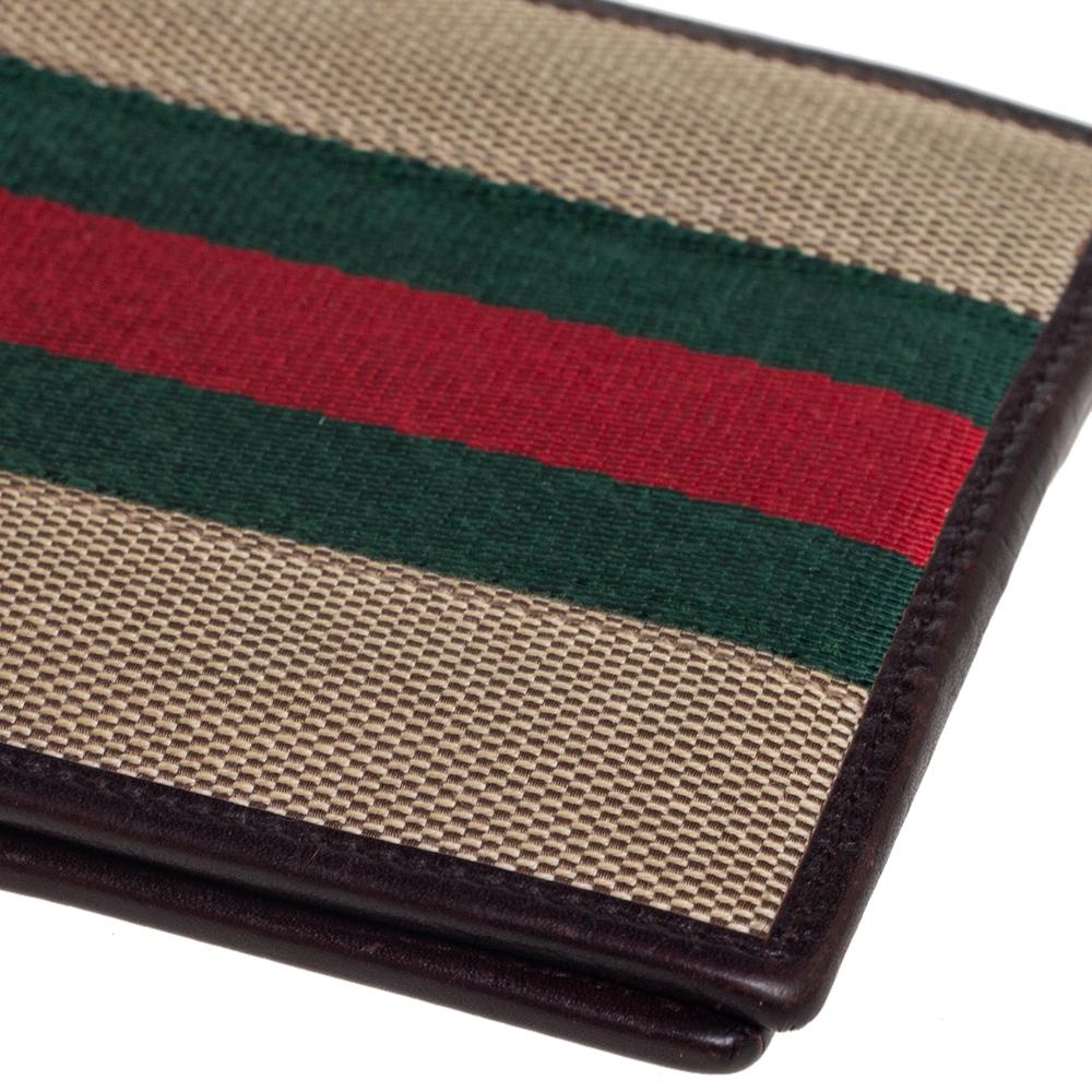 Embody the very definition of elegance and class with this wallet from the House of Gucci. It is styled using brown leather and canvas, with the iconic Web stripe defining its exterior. The bi-fold feature opens to a leather-lined interior. Use this