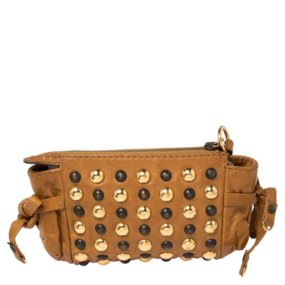 This Gucci clutch is built to suit your stylish ensembles. Crafted in Italy, it is made from quality leather and comes in a brown hue. It is complete with a Hysteria emblem as well as studs on the front and a wristlet. It has ties on the sides and a
