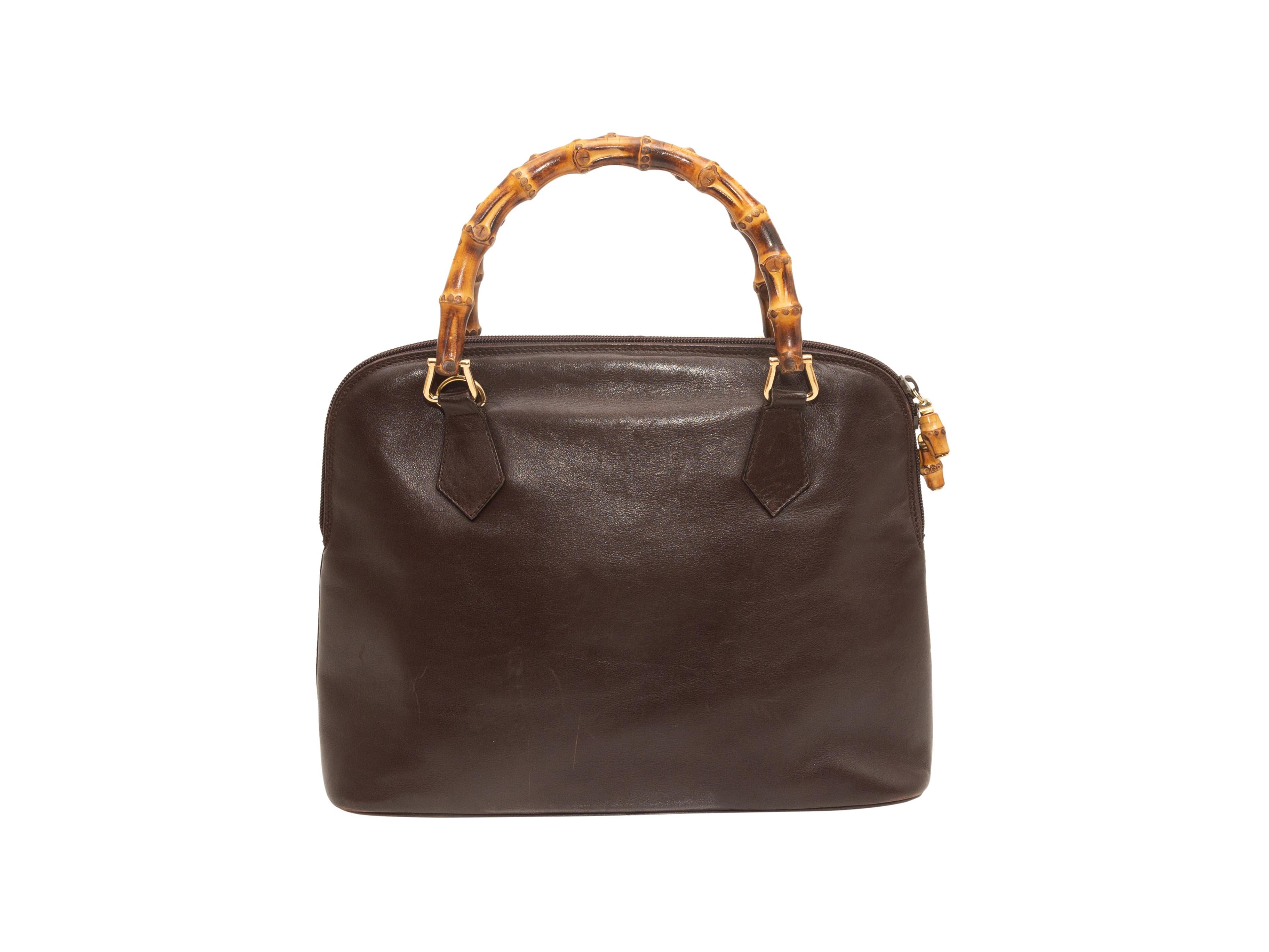 Product details: Vintage brown leather handbag by Gucci. Gold-tone hardware. Dual bamboo top handles. Zip closure at top. 12.5