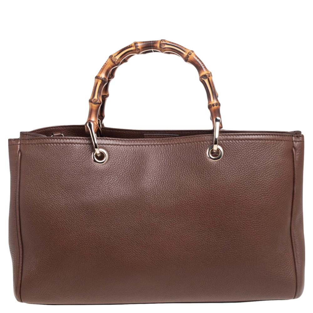 Designed with Gucci’s signature Bamboo top handles, this Shopper tote is instantly recognizable among fashion brand lovers. This elegant style is finely created from brown leather and is finished with an embossed Gucci trademark on the front. The