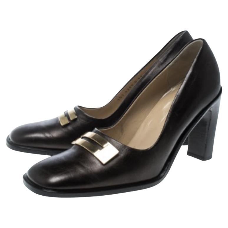 Dai un tocco di eleganza al tuo look da ufficio con queste décolleté di Gucci. Sono realizzate in pelle marrone e presentano accenti metallici con logo sulla tomaia e punta quadrata. Le solette sono foderate in pelle e riportano il nome del marchio.